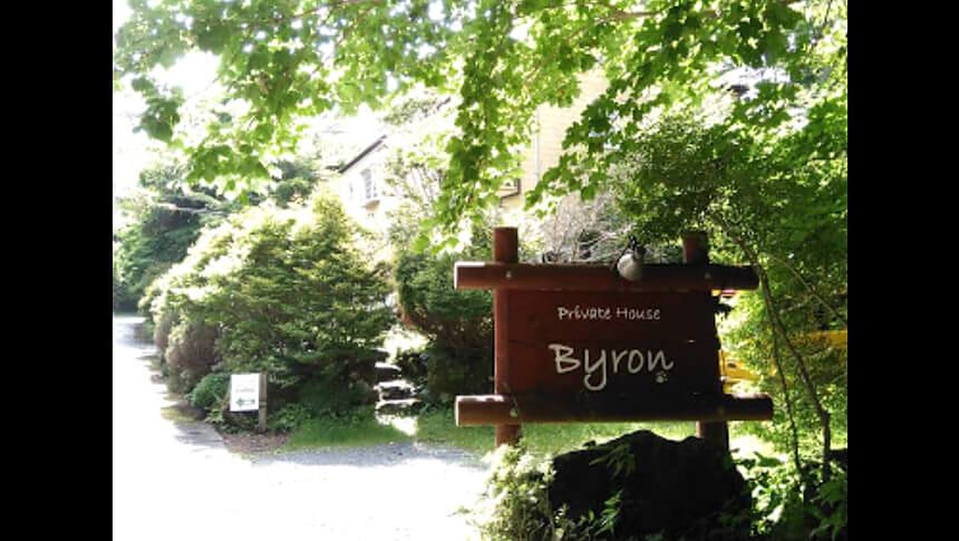 緑に囲まれたPrivate House Byronの木製看板